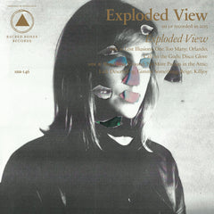 Exploded View album cover featuring a black and white portrait with fragmented face elements and gold text design