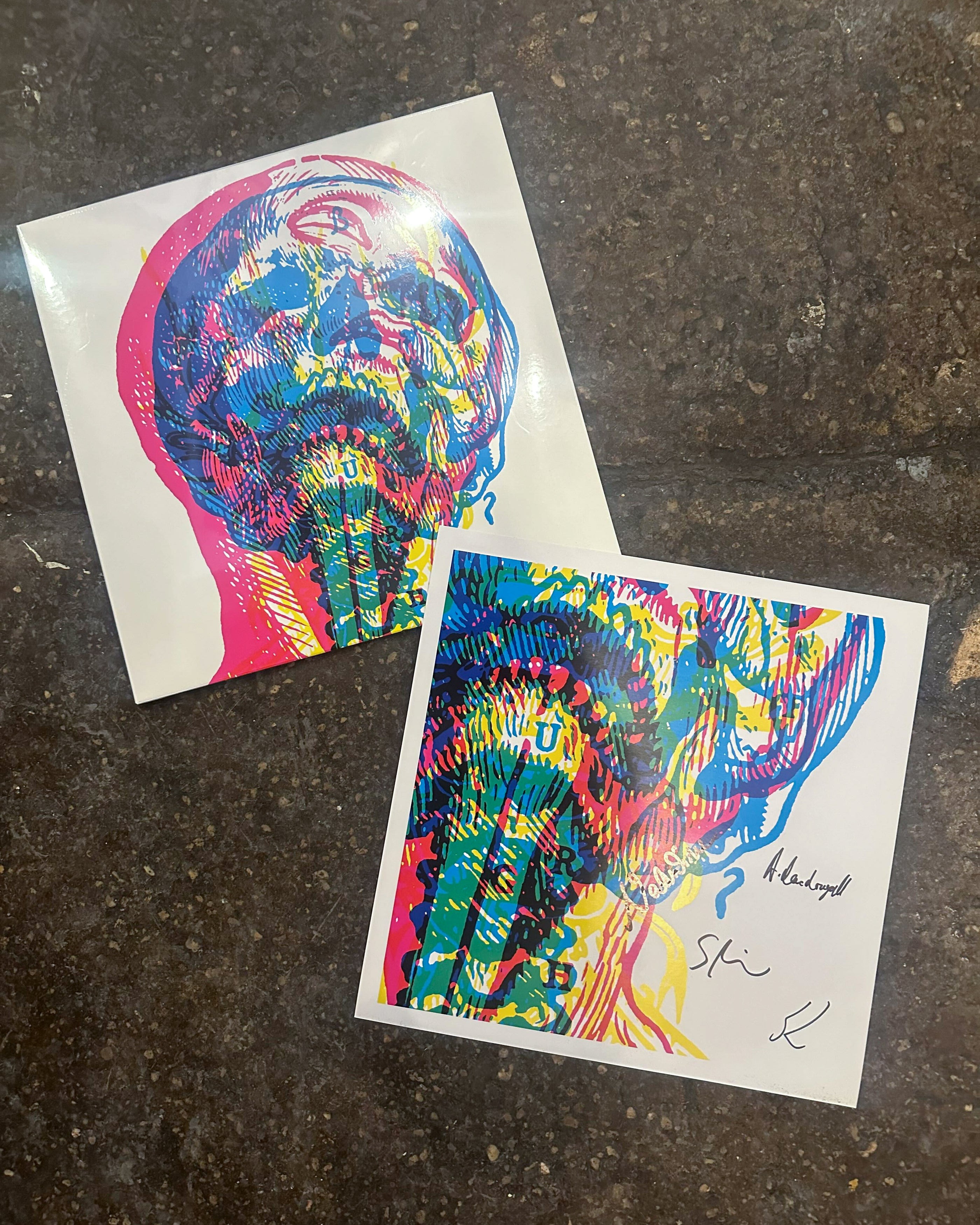 Two colorful abstract art prints of human skulls and spines with signatures for Immigration Solidarity Record Raffle