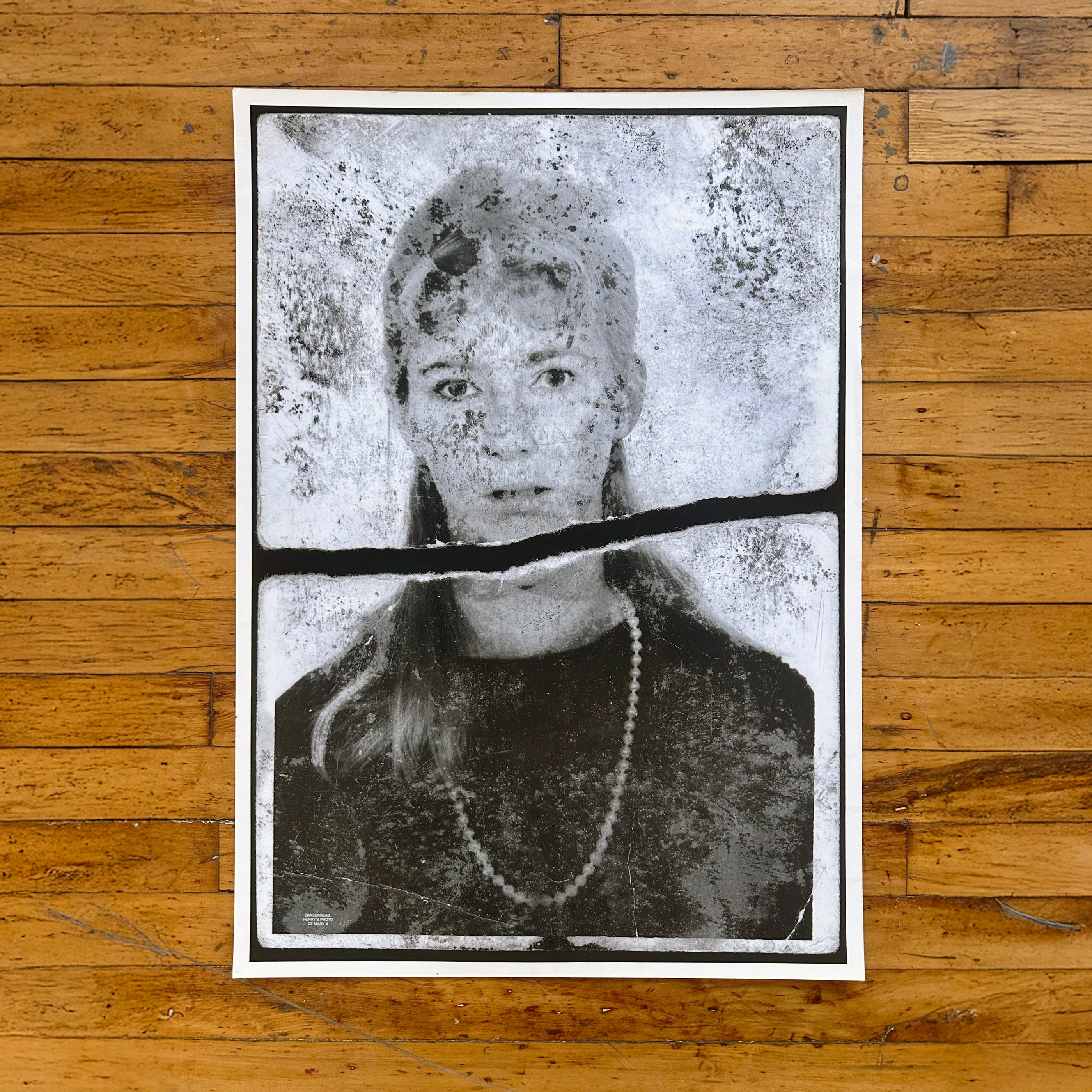Mary X Poster featuring a distressed black and white portrait of a woman with a necklace on a wooden floor background
