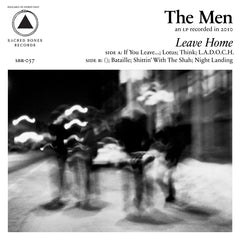 Blurred black and white photo of four people walking on a city street at night with album title Leave Home